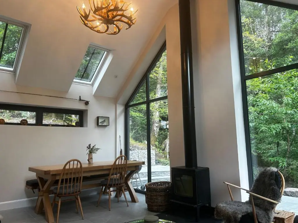 a dining room with a table and chairs and a chandelier at Aldernaig Mill in Invergarry