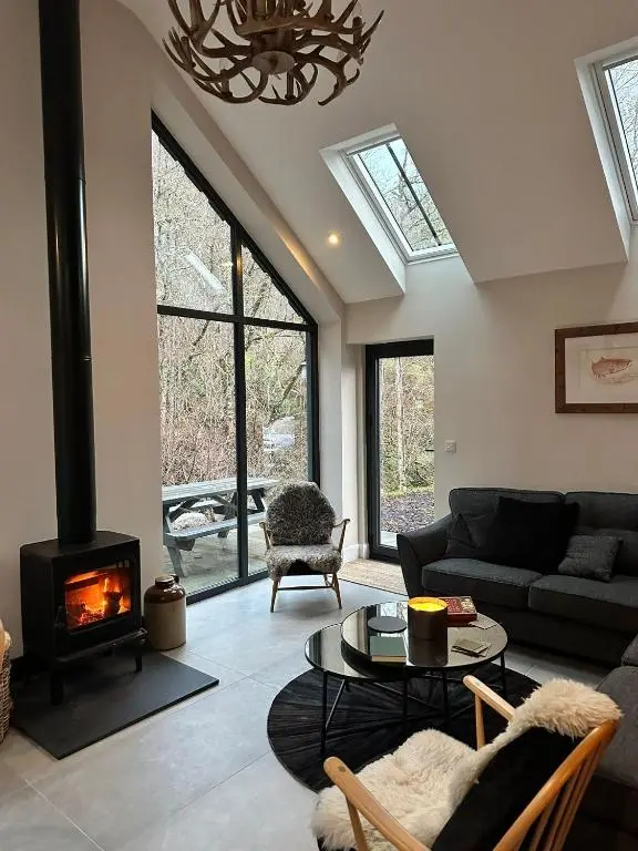 a living room with a couch and a fireplace at Aldernaig Mill in Invergarry