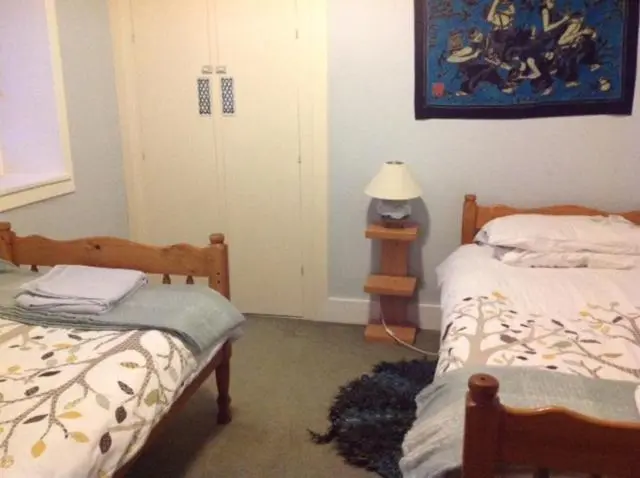 a bedroom with two beds and a lamp in it at Fraoch Lodge in Boat of Garten
