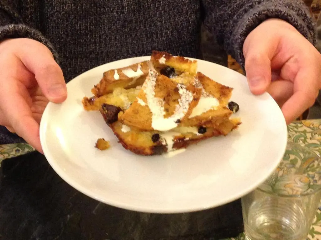 a person holding a white plate with a piece of cake at Fraoch Lodge in Boat of Garten