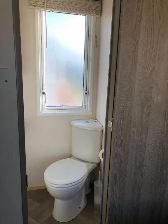 a bathroom with a toilet and a window at Ballies Retreat in Lossiemouth