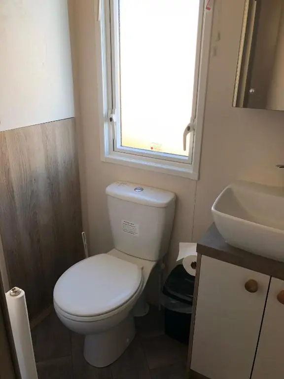a bathroom with a toilet and a sink and a window at Ballies Retreat in Lossiemouth