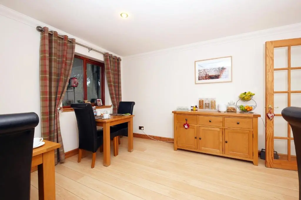 a living room with a table and a dining room at Culliss House B&B in Inverness