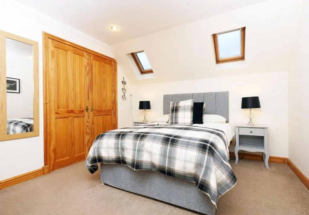 a bedroom with a bed and a wooden door at Culliss House B&B in Inverness