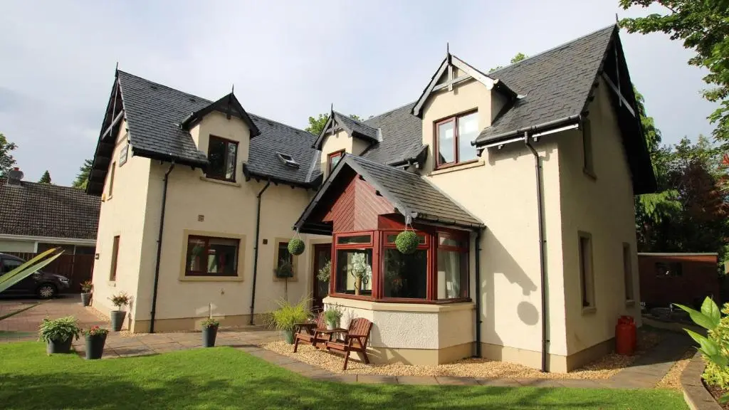 a white house with a black roof at Culliss House B&B in Inverness
