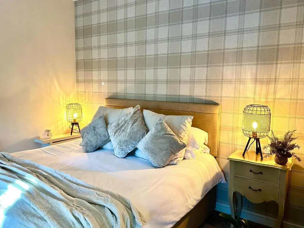 a bedroom with a bed with pillows on it at Beechtree Cottage, Cairngorm Suite, Kirkmichael in Blairgowrie