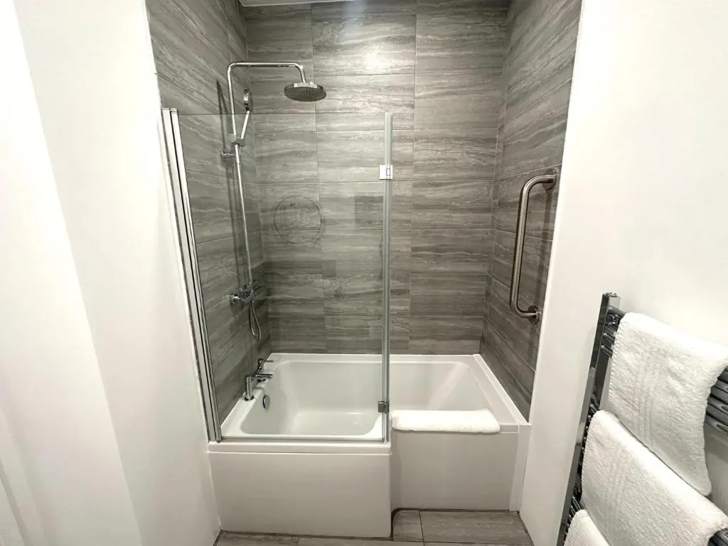 a bathroom with a shower and a white bath tub at Beechtree Cottage, Cairngorm Suite, Kirkmichael in Blairgowrie