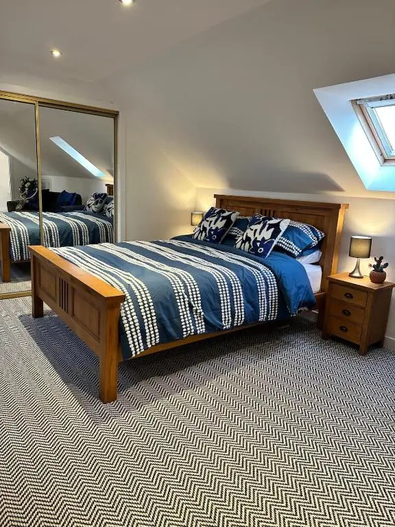 a bedroom with a bed and a large mirror at An Cuiltheann Apartment in Turriff
