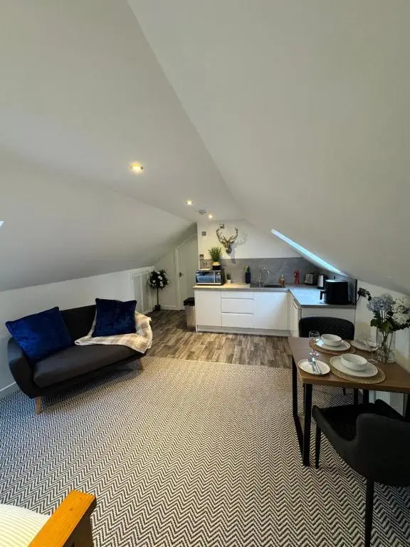 a living room with a couch and a table at An Cuiltheann Apartment in Turriff
