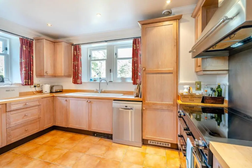 a kitchen with wooden cabinets and a sink at 7 Bed in Strathdon oc-t30594 in Strathdon