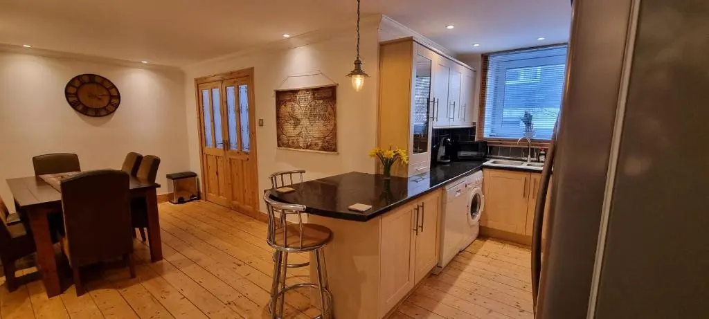 a kitchen with a counter and a table and a dining room at Beautiful 3 bedroom house short walk from the beach in Nairn