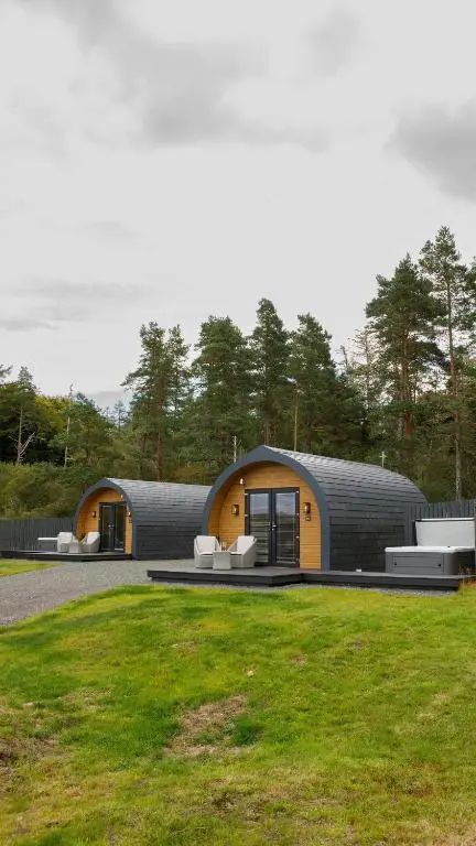 a large circular building with a grassy field at Shin View Pods in Lairg