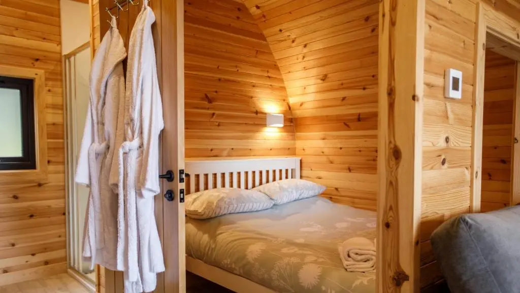 a bedroom with a bed in a wooden cabin at Shin View Pods in Lairg