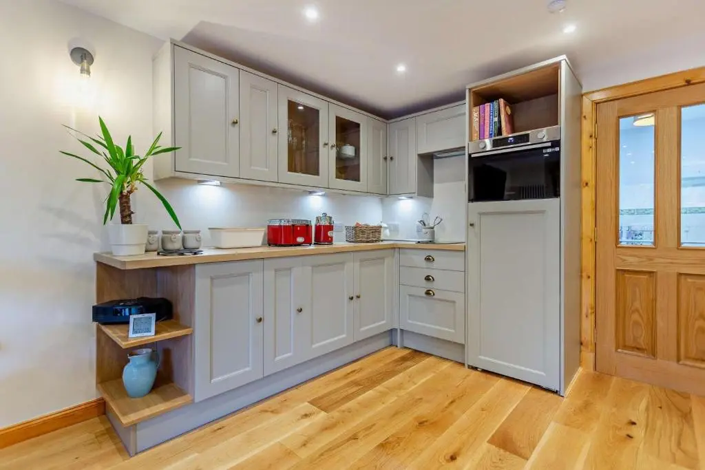 a kitchen with white cabinets and a refrigerator at 1 Bed in Strathpeffer oc-h30077 in Strathpeffer