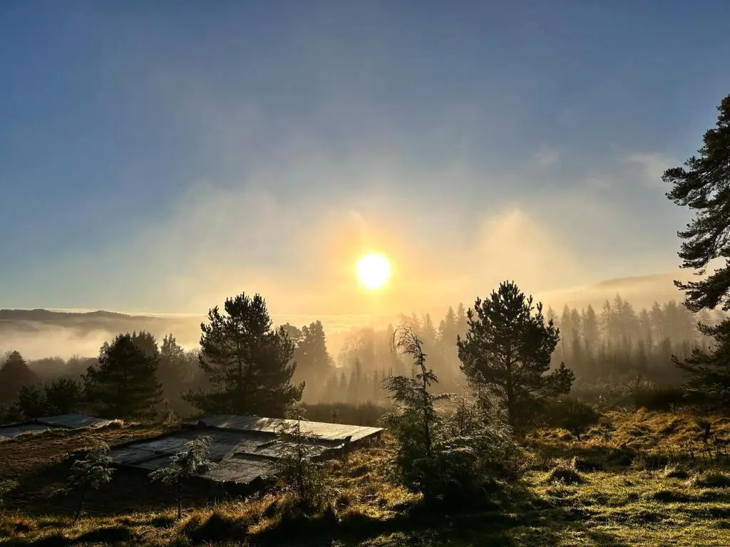 a misty sunrise on a mountain with a cabin at Beechtree Cottage, Ardle Family Room, Kirkmichael in Kirkmichael