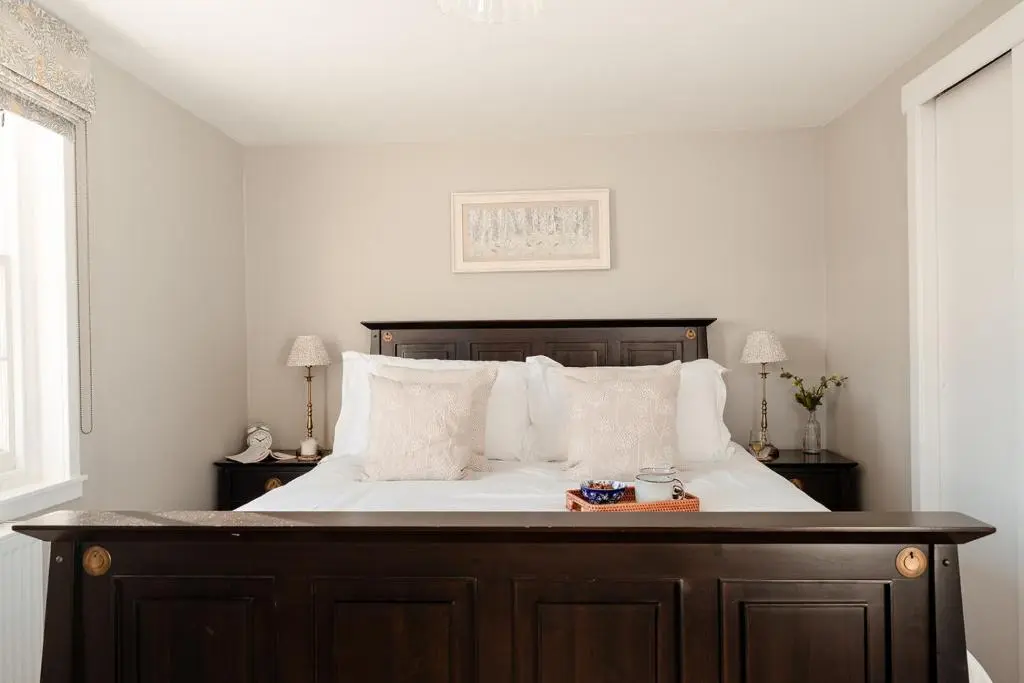 a bedroom with a large bed with white sheets and pillows at Park Cottage - Seasgair Lodges in Kingussie