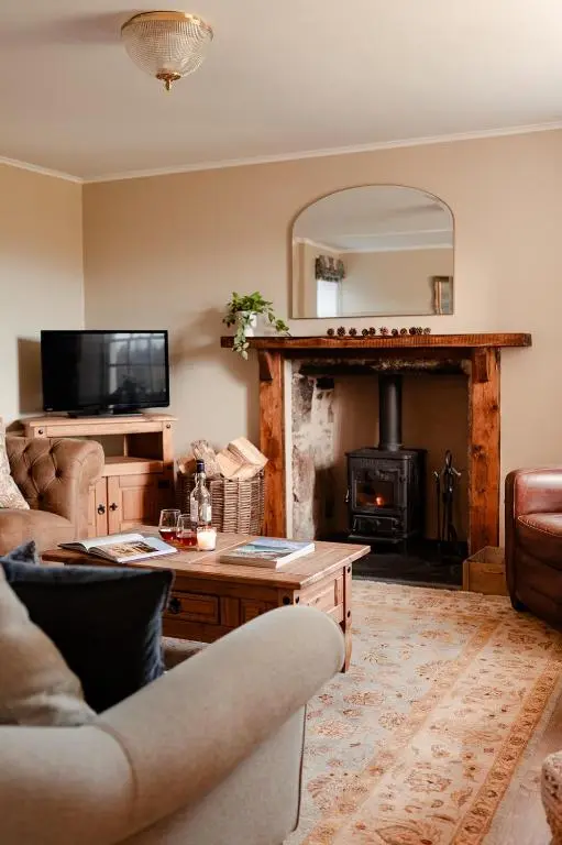 a living room with a couch and a fireplace at Park Cottage - Seasgair Lodges in Kingussie