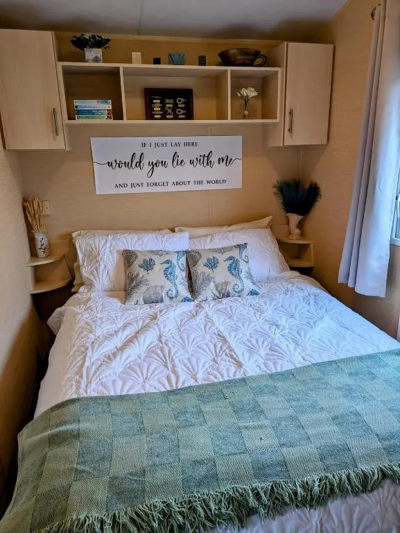 a bedroom with a bed with a sign above it at Aurora on the Dunes- Cozy Coastal Retreat with Scenic Views in Lossiemouth