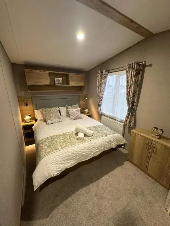 a bedroom with a large bed and a window at Clearwater View - Stunning sea views from large deck in Burghead