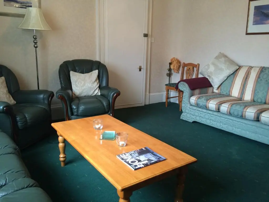 a living room with a coffee table and chairs at Ardgarry Holiday House in Inverness