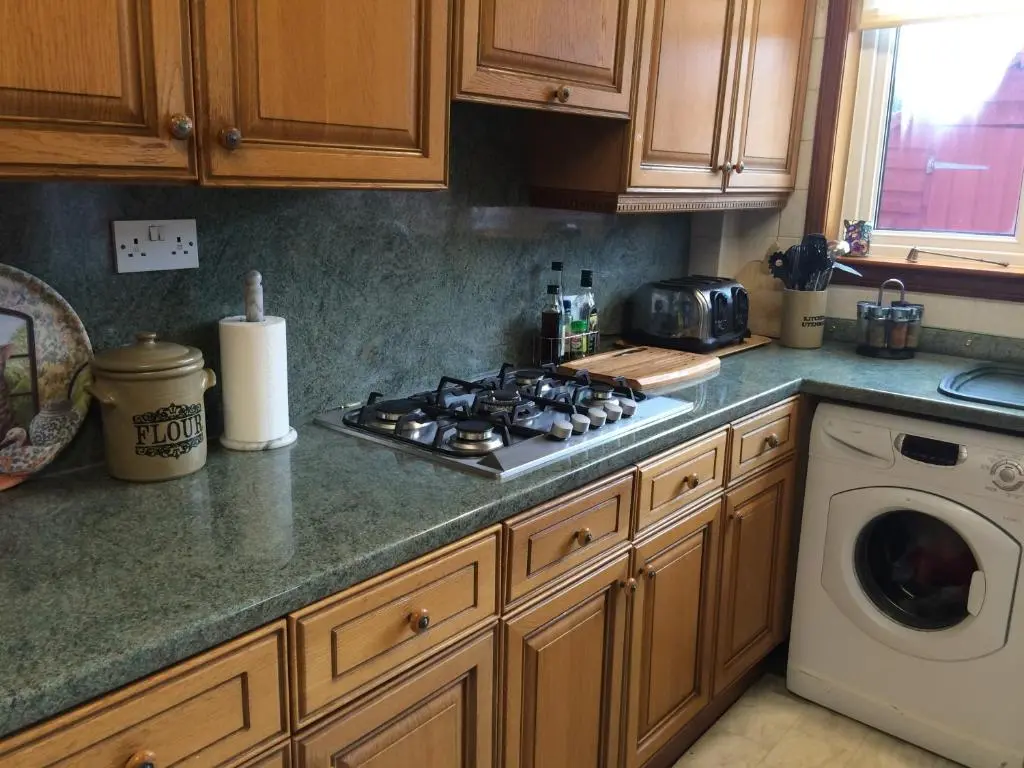 a kitchen with a stove and a washing machine at Ardgarry Holiday House in Inverness