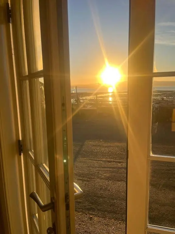 a view of the sunset from a window at North Coast Property - Avoch Beach House - Luxury house with sea views in Avoch