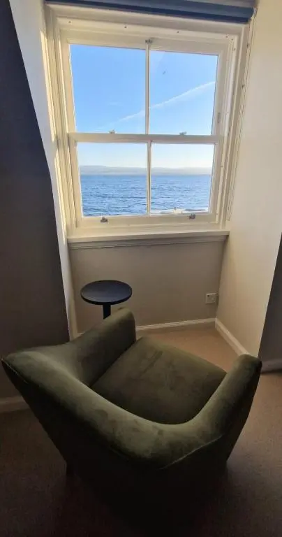 a room with a green chair and a large window at North Coast Property - Avoch Beach House - Luxury house with sea views in Avoch