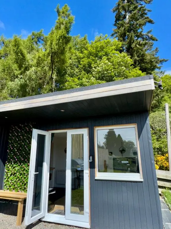 a small shed with a door and windows at Brae Cabin in Inverness
