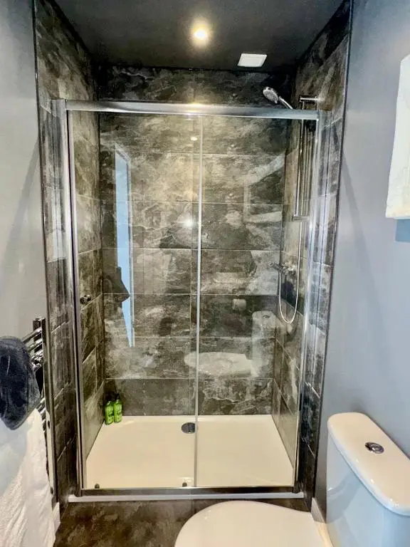 a shower stall in a bathroom with a toilet at Brae Cabin in Inverness