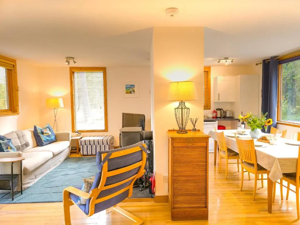 a living room with a couch and a table and chairs at Taigh Mathair Taigh Mathair in Nethy Bridge