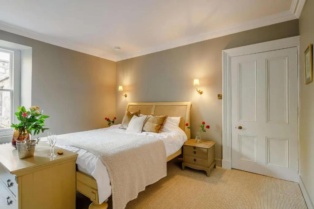a bedroom with a bed and a window and a door at Burnhervie House in Inverurie