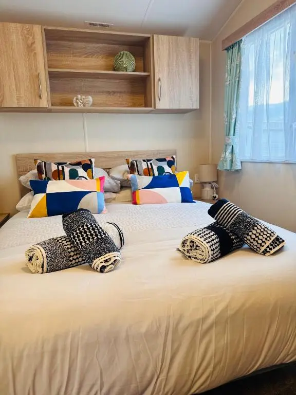 a bedroom with two beds with cheetah pillows on them at Little Cha-Am Caravan Hire at Silver Sands in Lossiemouth