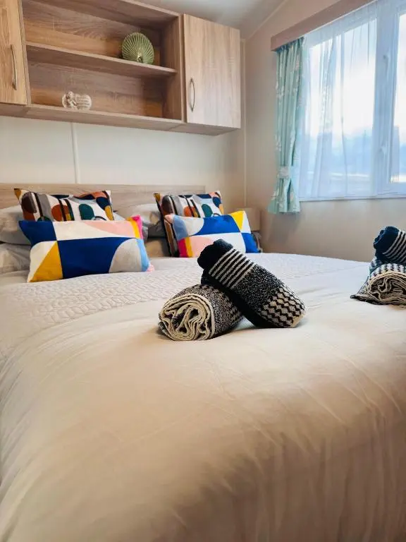 a bedroom with two beds with pillows on them at Little Cha-Am Caravan Hire at Silver Sands in Lossiemouth