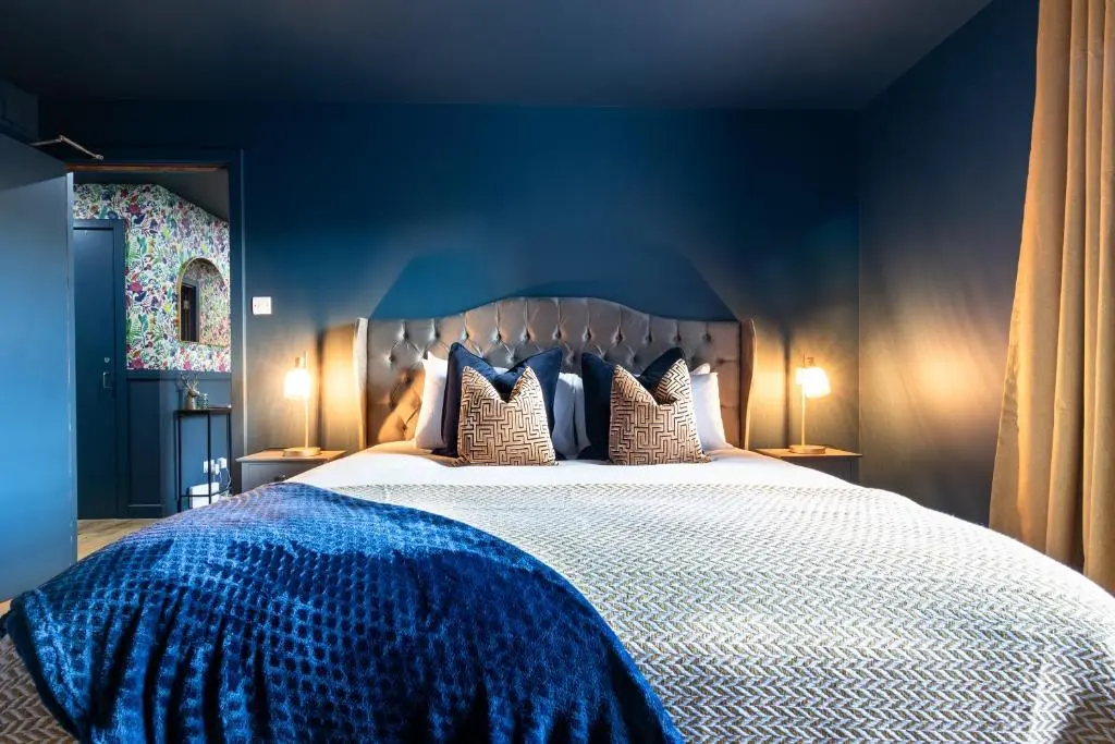 a blue bedroom with a large bed with pillows at Ness in the City in Inverness