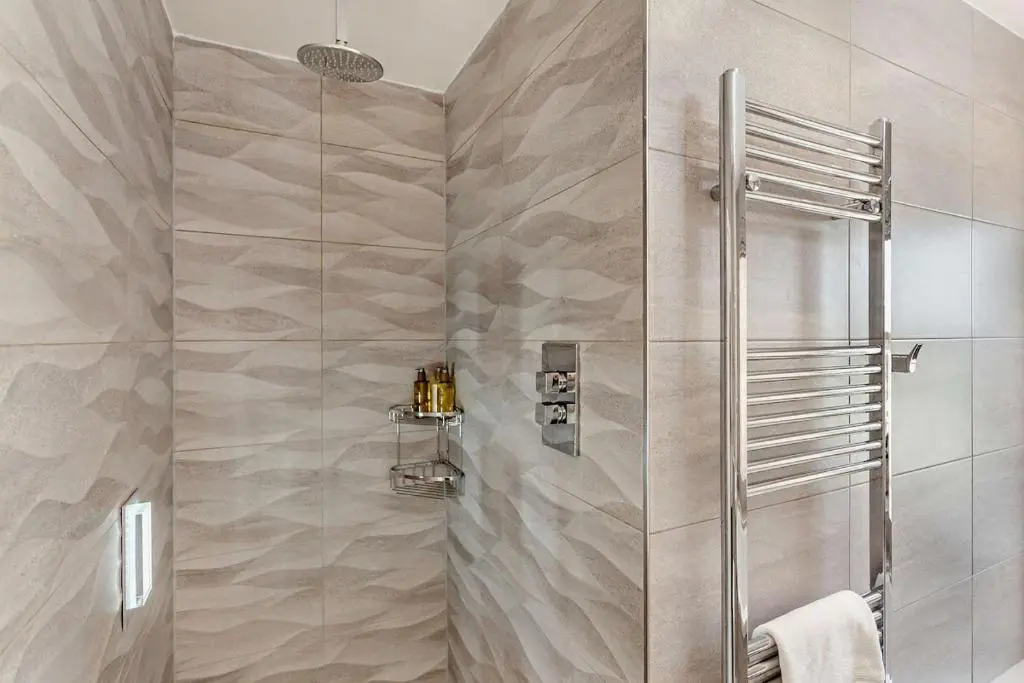 a shower stall in a bathroom with marble tiles at Glenmore Lodge in Skye of Curr