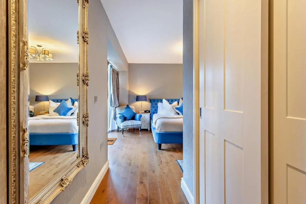a mirror in a room with two beds at Glenmore Lodge in Skye of Curr