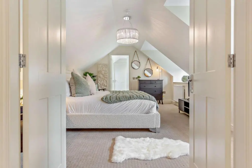 a white bedroom with a bed and a mirror at Cairngorm Cottage in Skye of Curr
