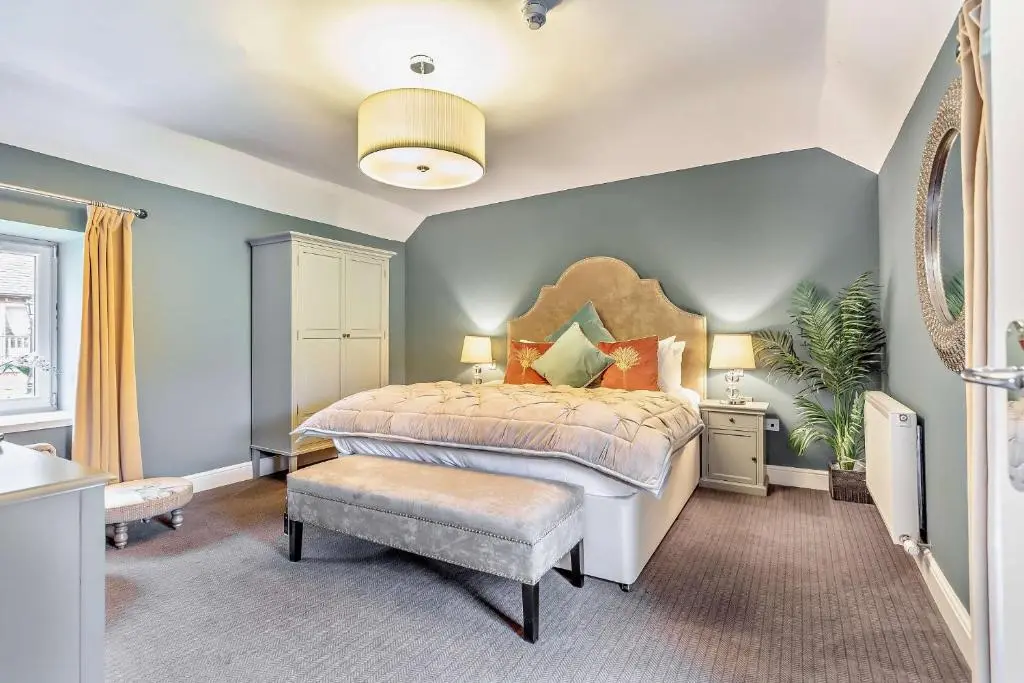 a bedroom with a king sized bed and blue walls at Cairngorm Cottage in Skye of Curr