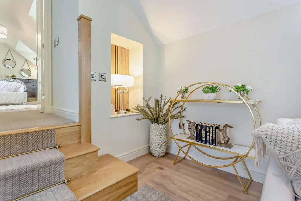 a bedroom with a bed and a mirror and a chair at Cairngorm Cottage in Skye of Curr