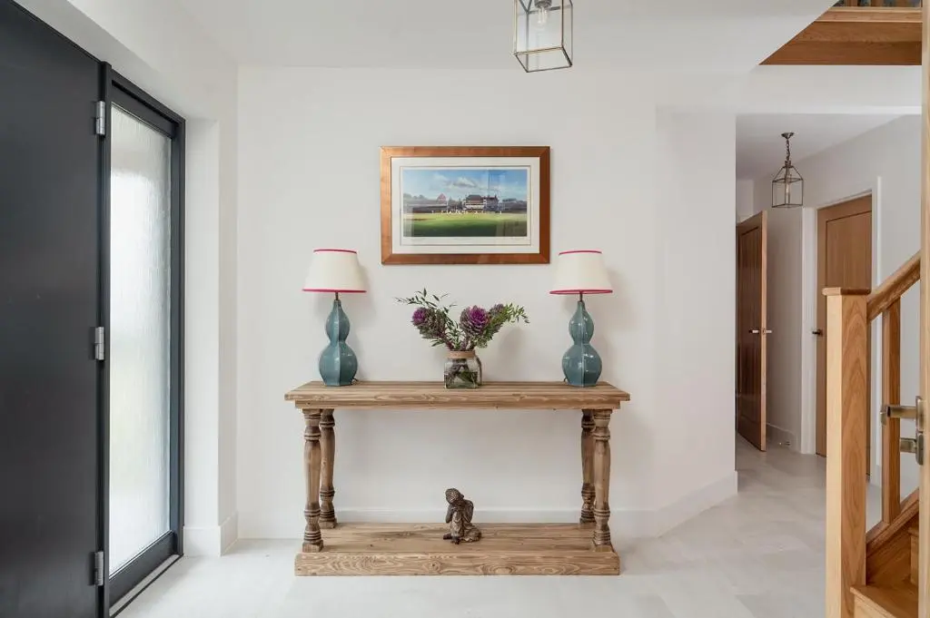 a console table with two lamps on it in a hallway at Osprey's Nest - Seasgair Lodges in Broomhill Station