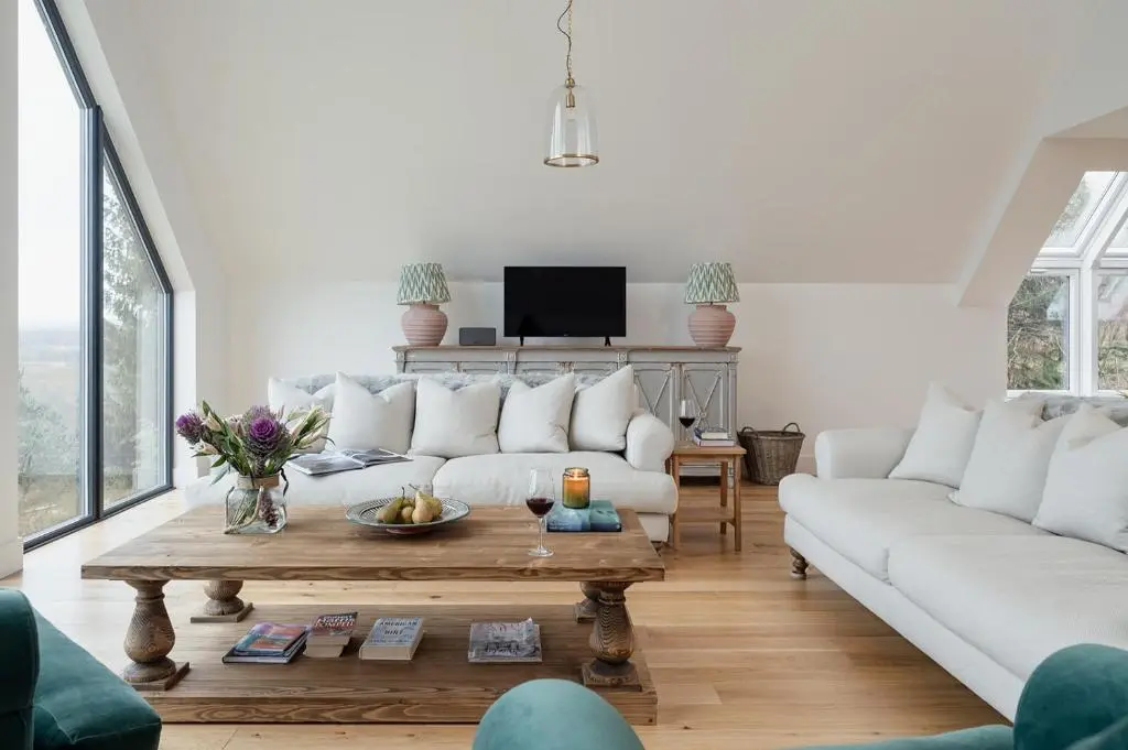 a living room with a white couch and a coffee table at Osprey's Nest - Seasgair Lodges in Broomhill Station