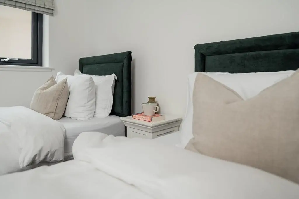 a bedroom with two beds and a couch at Osprey's Nest - Seasgair Lodges in Broomhill Station