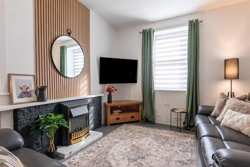 a living room with a couch and a fireplace at Ness Heights, Spacious City Centre Townhouse in Inverness