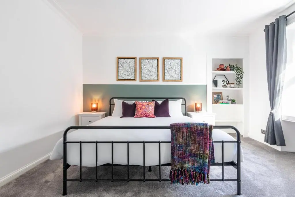a bedroom with a large white bed with pillows at Ness Heights, Spacious City Centre Townhouse in Inverness