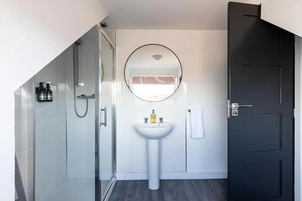 a bathroom with a sink and a shower and a mirror at Ness Heights, Spacious City Centre Townhouse in Inverness