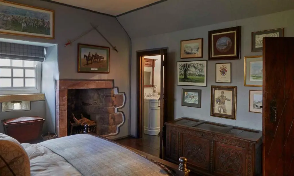 a bedroom with a fireplace and a bed in a room at Forter Castle in Blairgowrie