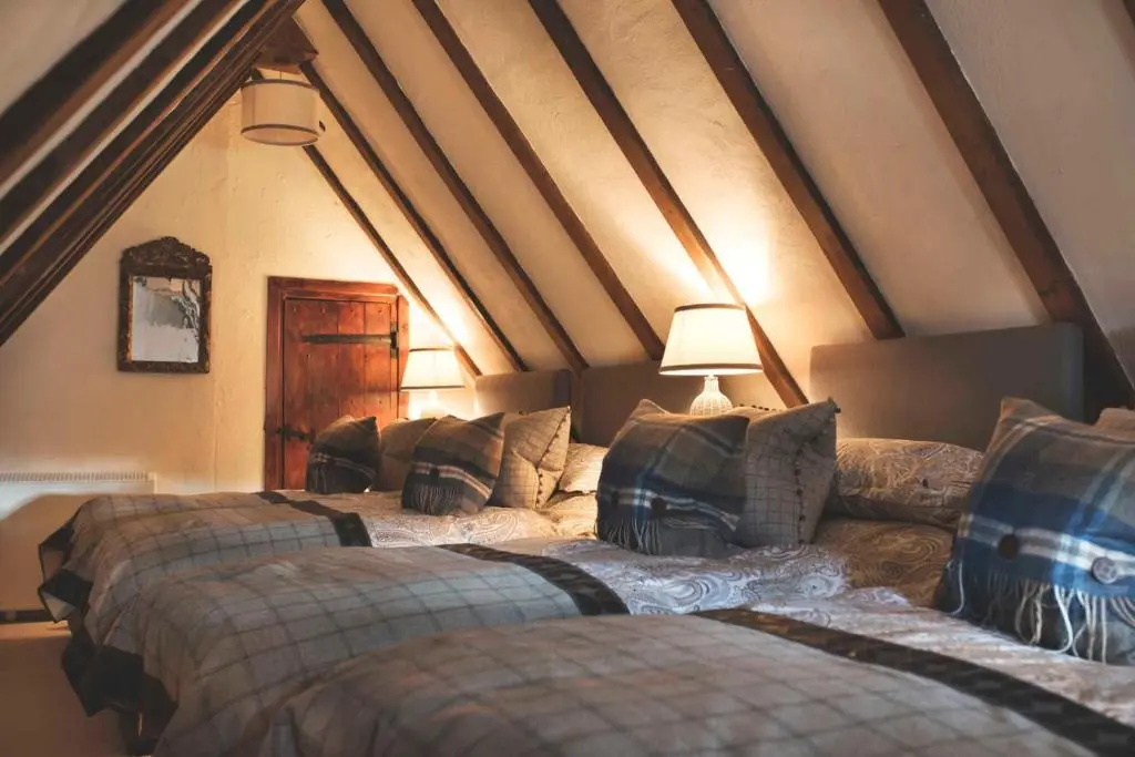 a room with two beds and a couch in a attic at Forter Castle in Blairgowrie