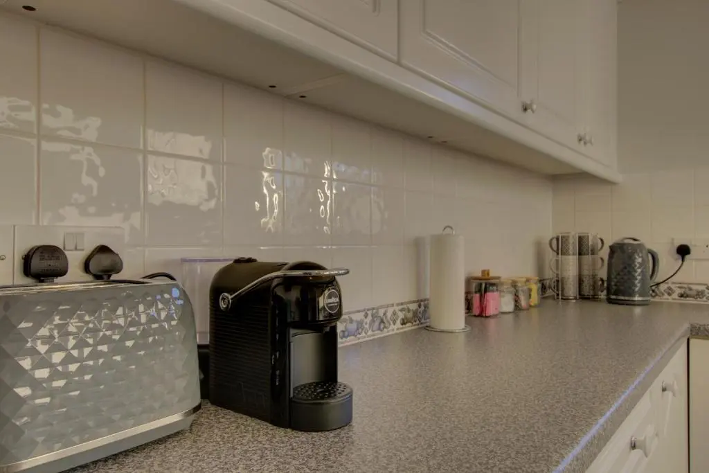 a kitchen with a coffee maker sitting on a counter at 2 Links View, Brora in Brora
