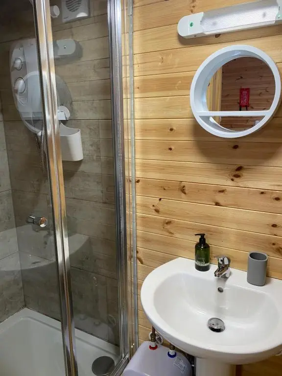 a bathroom with a sink and a shower at An Cabar - Cabin in Aviemore, Cairngorms NP in Aviemore