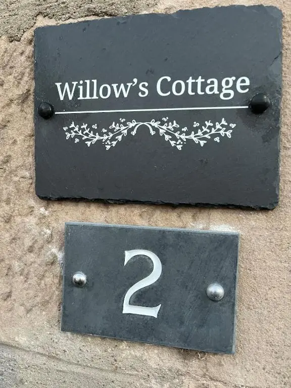 a sign on the side of a building with the number two at Willow's Cottage in Auldearn